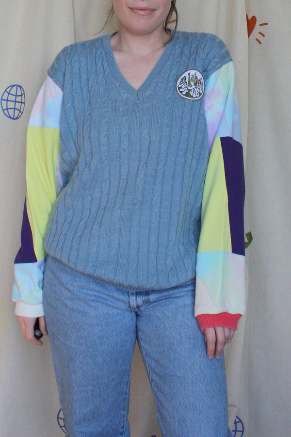 upcycled blue cable knit v-neck sweater with colourful patchwork sleeves, repurposed in canada