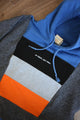 upcycled blue, black, grey and orange hoodie, repurposed in canada, detail shot of 'no labels, just vibes.' embroidery