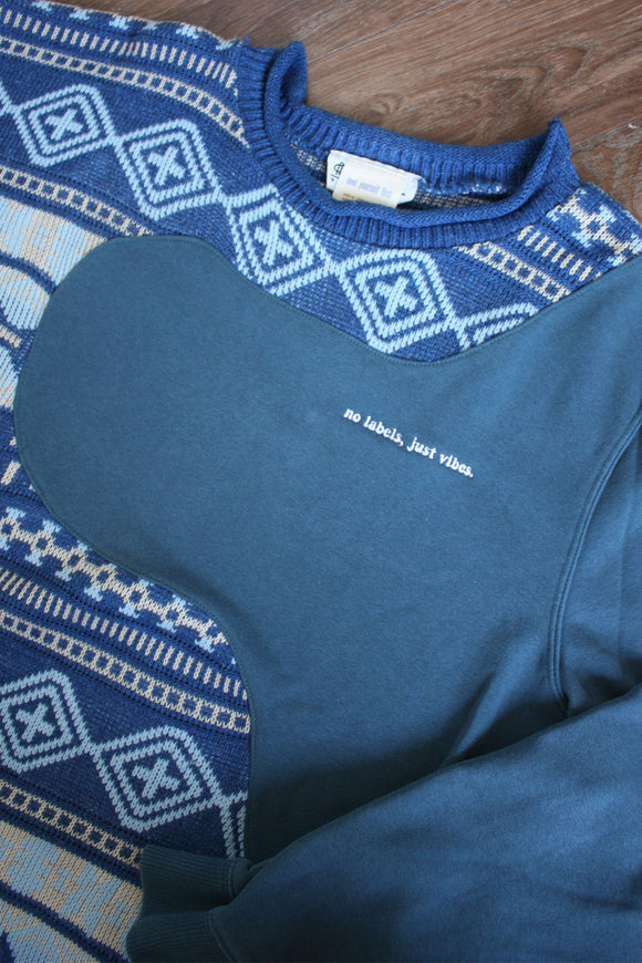 upcycled grandma sweater, blue, cream and light blue print, repurposed in canada, detail shot of 'no labels, just vibes.' embroidery