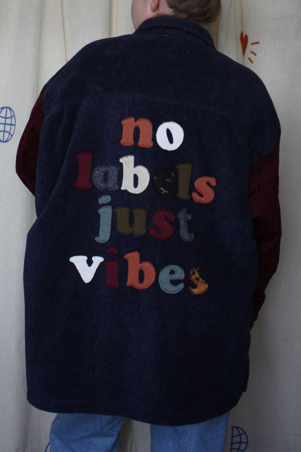 navy shacket with plum sleeves, and lettering on the back with our motto 'no labels, just vibes.' upcycled in canada