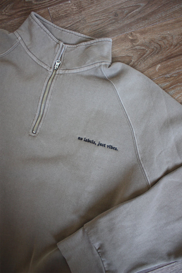 brown upcycled half zip sweater, embroidered with our motto 'no labels, just vibes.'