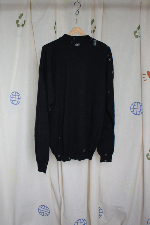 black knit jumper with visible mending and 'no labels, just vibes.' patch, upcycled in canada