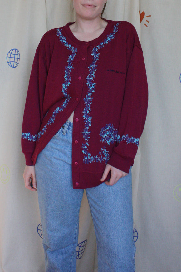 red upcycled button up sweater, with floral details around sleeves and front, repurposed in canada