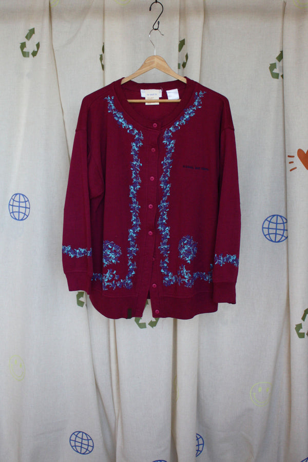 red upcycled button up sweater, with floral details around sleeves and front, repurposed in canada