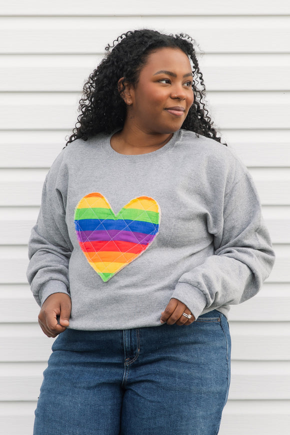 quilted rainbow heart sewn on heather grey sweater, unisex and oversized fit, sewn in canada