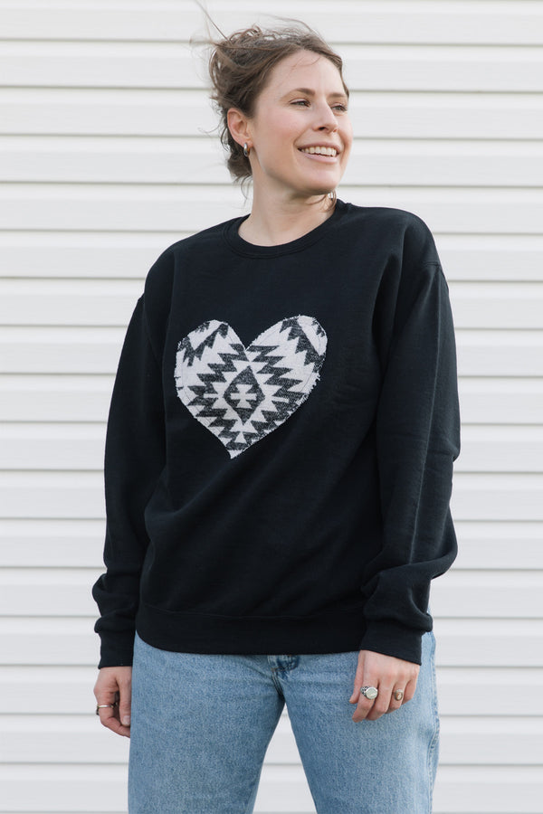 Indigenous white and black pattern heart sewn on a black sweater, unisex and oversized fit, sewn in canada