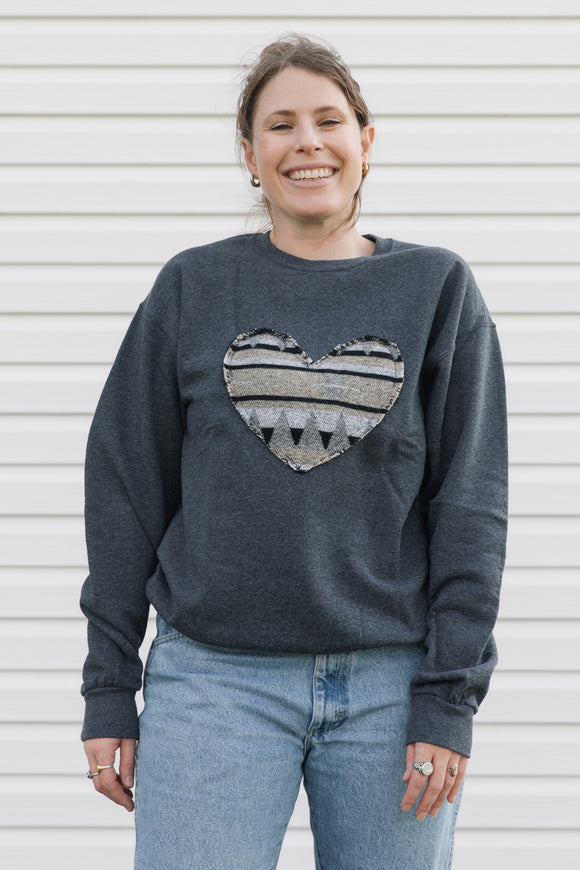 Indigenous beige and black printed heart sewn on charcoal sweater, unisex and oversized fit, sewn in canada