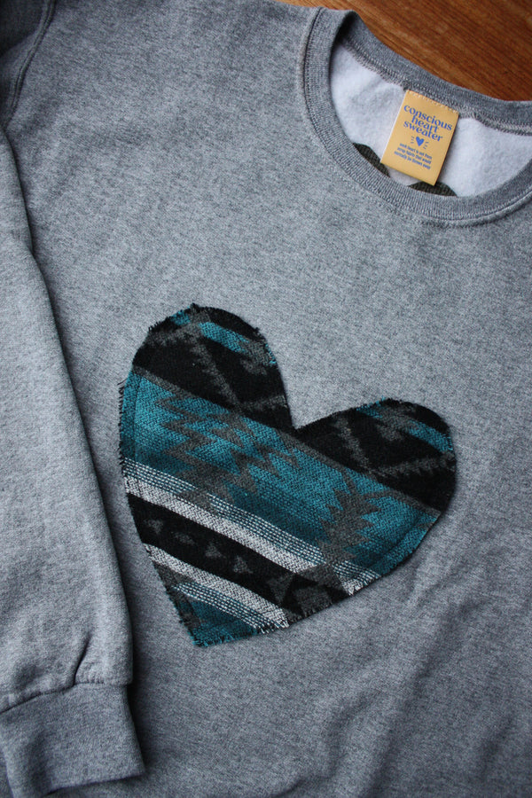 Indigenous woven blue heart sewn on heather grey sweater, unisex and oversized fit, sewn in canada