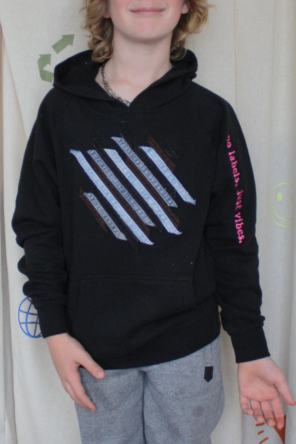 black upcycled hoodie worn by 9 year old, denim seams create cool design on the front, repurposed in canada