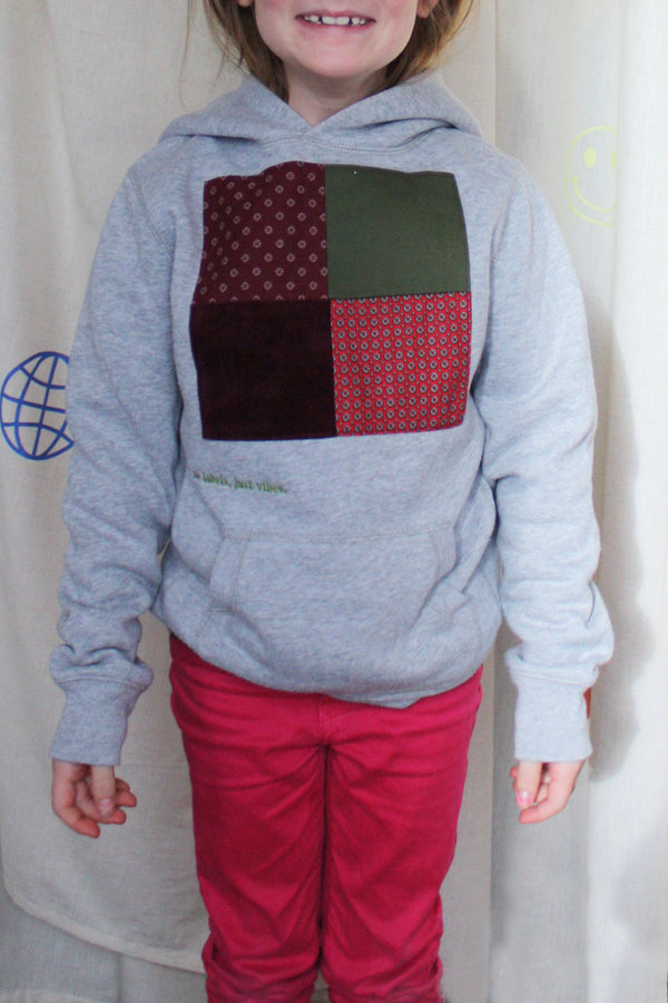 grey upcycled hoodie wrong by 6 year old, features maroon, green and red patterned squares, repurposed in canada