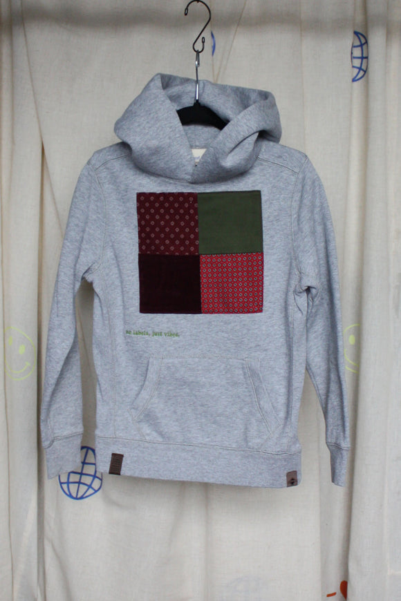 grey upcycled hoodie wrong by 6 year old, features maroon, green and red patterned squares, repurposed in canada