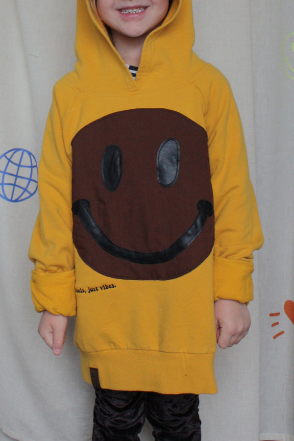 yellow upcycled hoodie worn by 6 year old, brown smiley face repurposed in canada