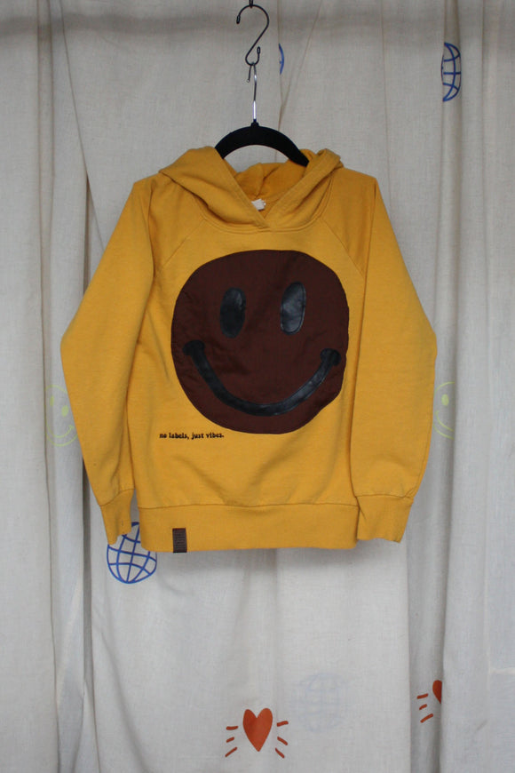 yellow upcycled hoodie worn by 6 year old, brown smiley face repurposed in canada