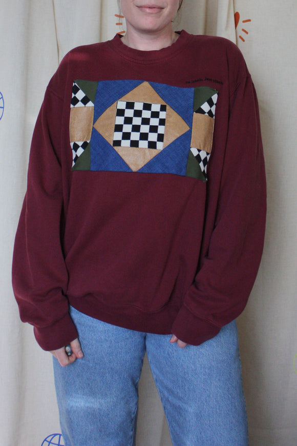 maroon upcycled sweater with geometric motif on the front, repurposed in canada