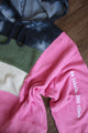 upcycled pink, green, cream and black hoodie, repurposed in canada, detail shot of 'no labels, just vibes.' embroidery