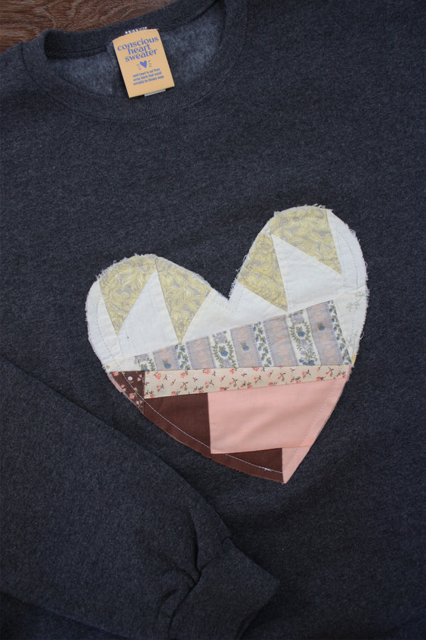 one of a kind quilted heart stitched on a charcoal sweater, unisex and oversized fit, hand cut and sewn in canada