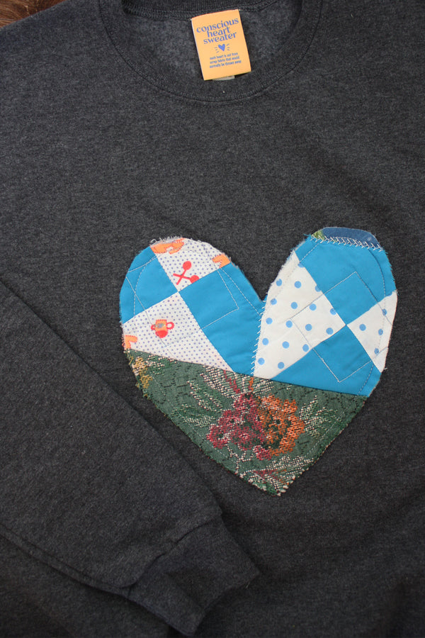 one of a kind quilted heart stitched on a charcoal sweater, unisex and oversized fit, hand cut and sewn in canada