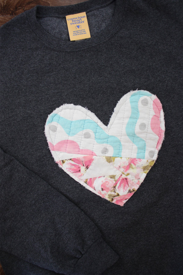 one of a kind quilted heart stitched on a charcoal sweater, unisex and oversized fit, hand cut and sewn in canada