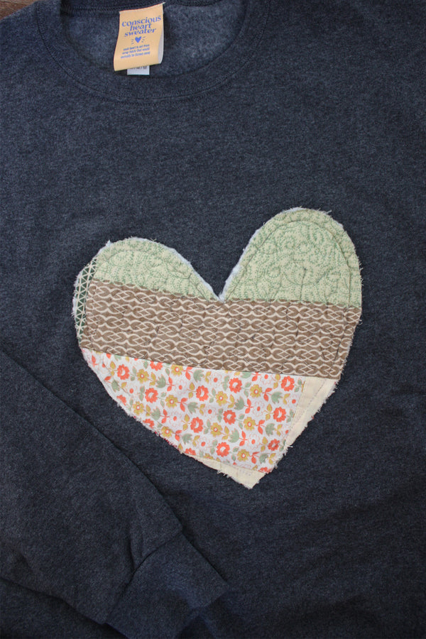 one of a kind quilted heart stitched on a charcoal sweater, unisex and oversized fit, hand cut and sewn in canada