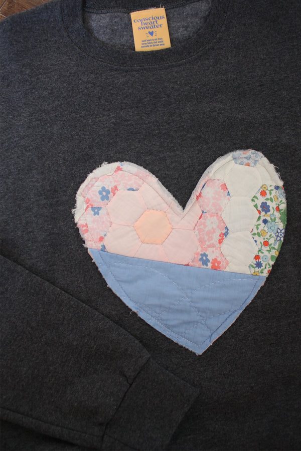 one of a kind quilted heart stitched on a charcoal sweater, unisex and oversized fit, hand cut and sewn in canada