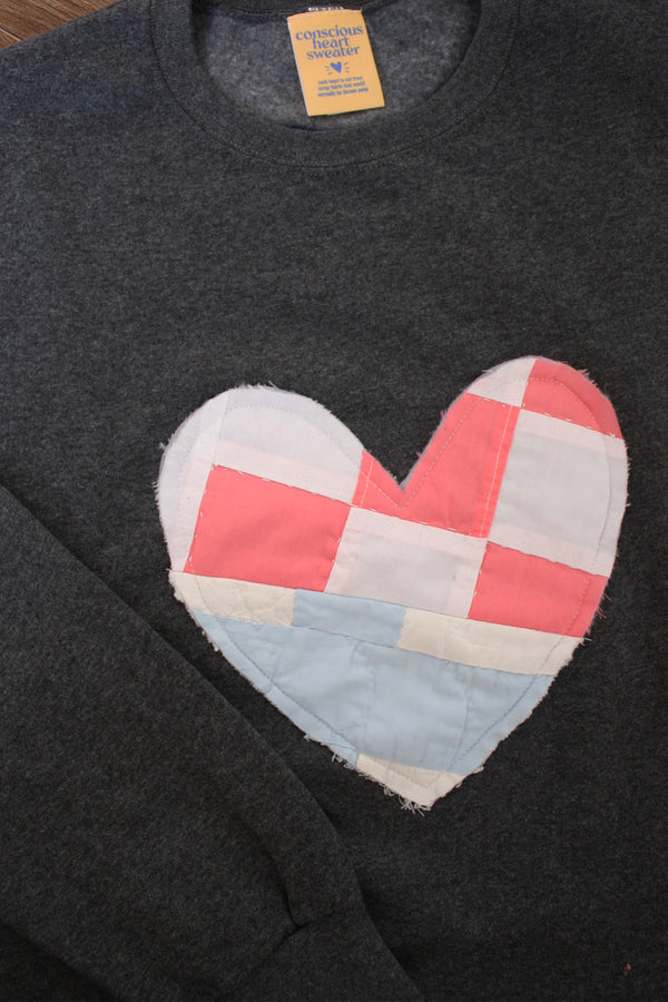 one of a kind quilted heart stitched on a charcoal sweater, unisex and oversized fit, hand cut and sewn in canada