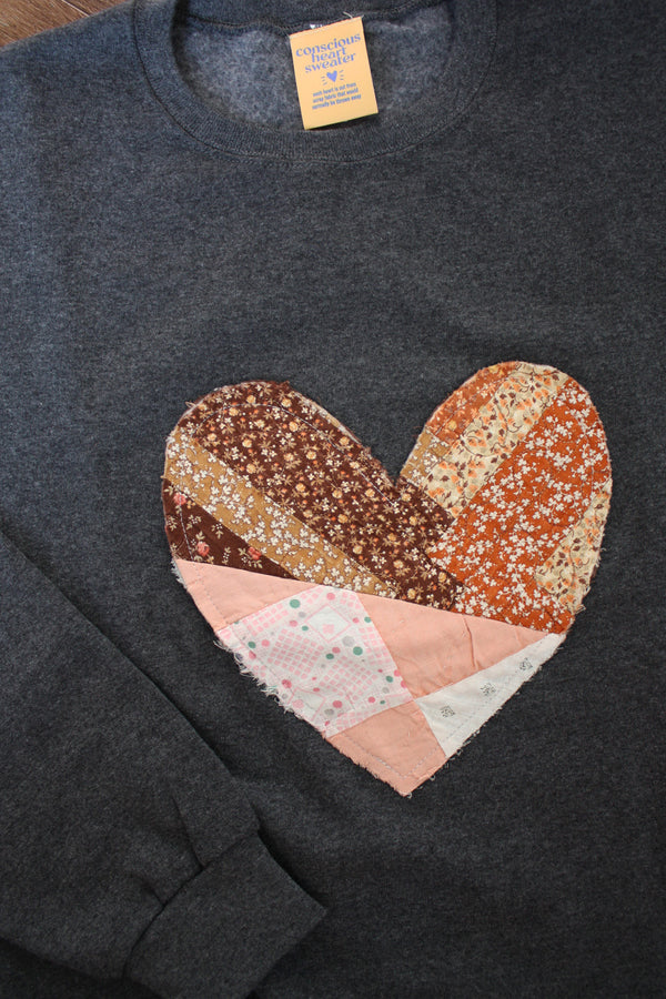 one of a kind quilted heart stitched on a charcoal sweater, unisex and oversized fit, hand cut and sewn in canada