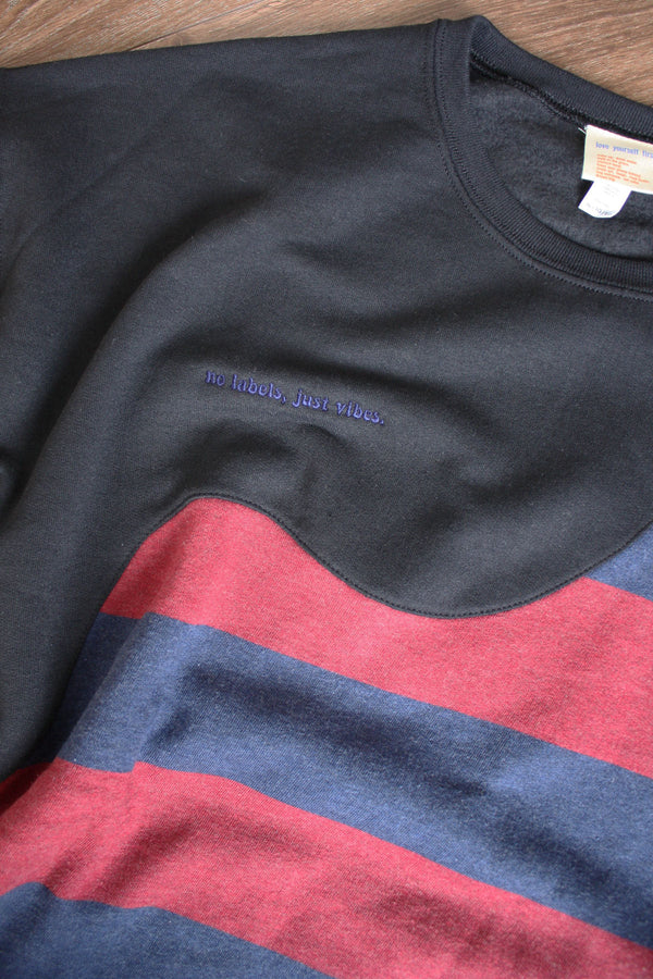 upcycled black red and navy striped sweater, repurposed in canada detail shot of 'no labels, just vibes.' embroidery