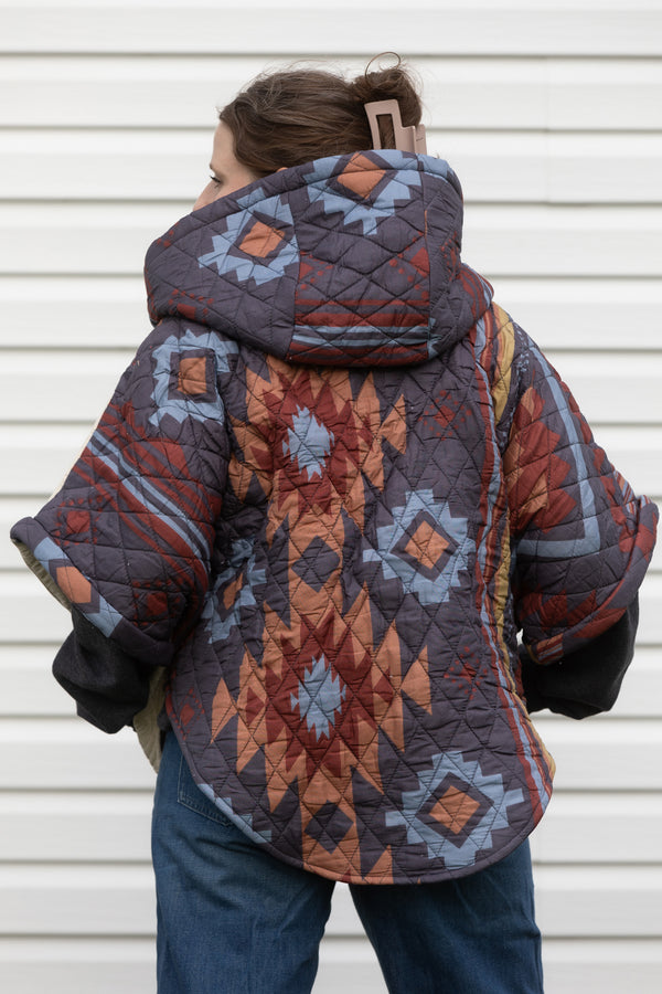 brown, blue and grey quilt upcycled into a poncho featuring fashionable hood, oversized fit and convenient pockets. made in canada