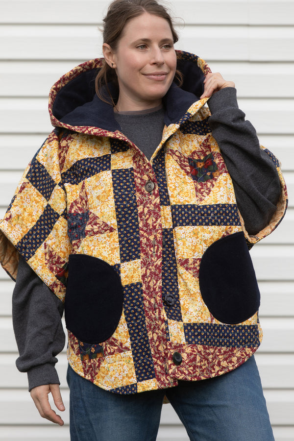 fall harvest quilt repurposed into poncho, featuring cozy hood and pockets that are lined with navy wool. made in canada