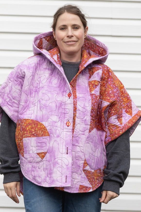 purple and orange quilt upcycled into oversized poncho, featuring a big hood and pockets. made in canada