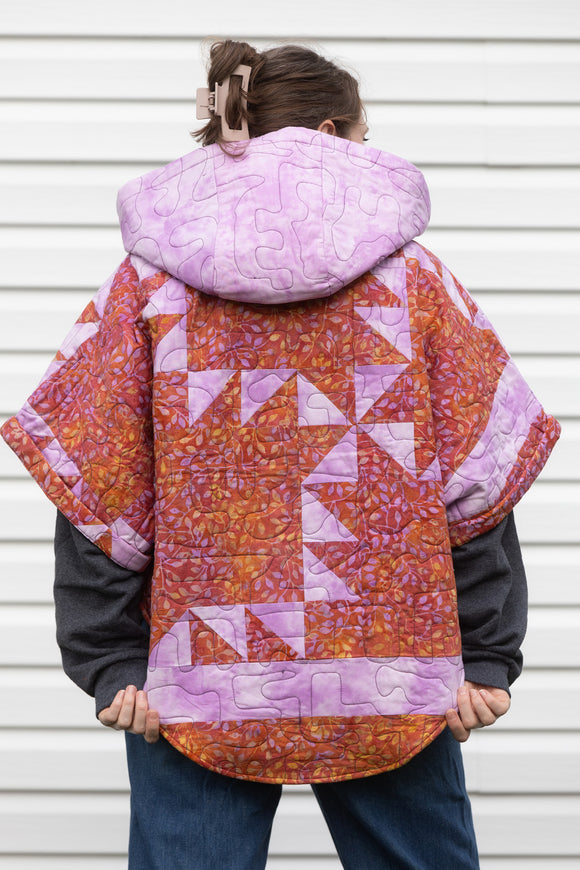 purple and orange quilt upcycled into oversized poncho, featuring a big hood and pockets. made in canada