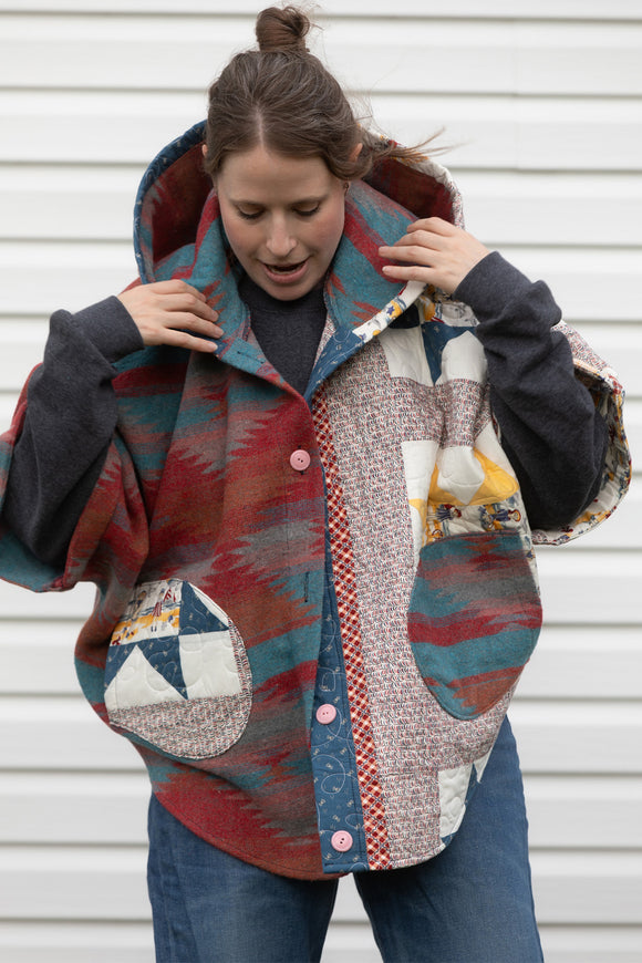 red, blue and yellow quilt upcycled into Clare poncho, featuring a big hood, pockets and oversized style, upcycled and made in canada