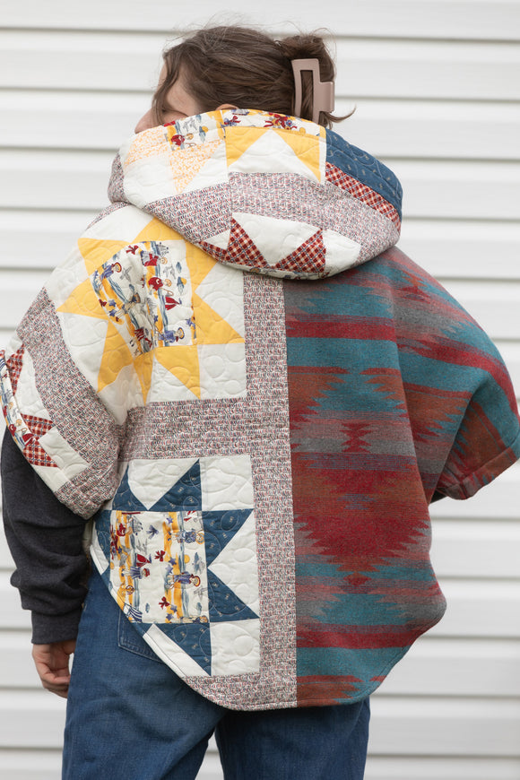 red, blue and yellow quilt upcycled into Clare poncho, featuring a big hood, pockets and oversized style, upcycled and made in canada