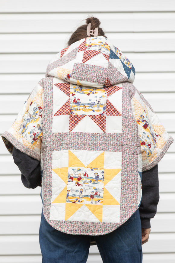 yellow and red star quilt upcycled into clare poncho, featuring a big hood, pockets and oversized style, upcycled and made in canada