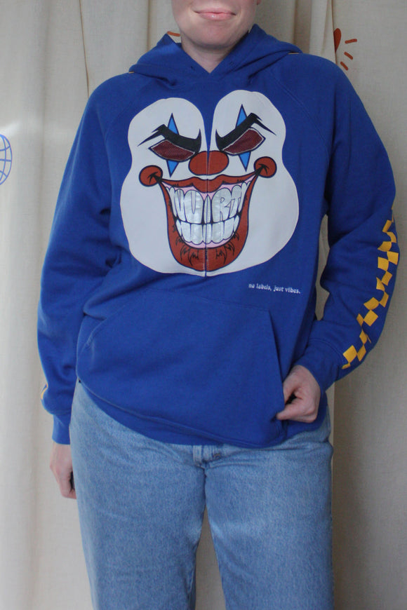 blue hoodie with wrestler mask graphic on the front and a yellow checkered pattern down the sleeves, repurposed in canada