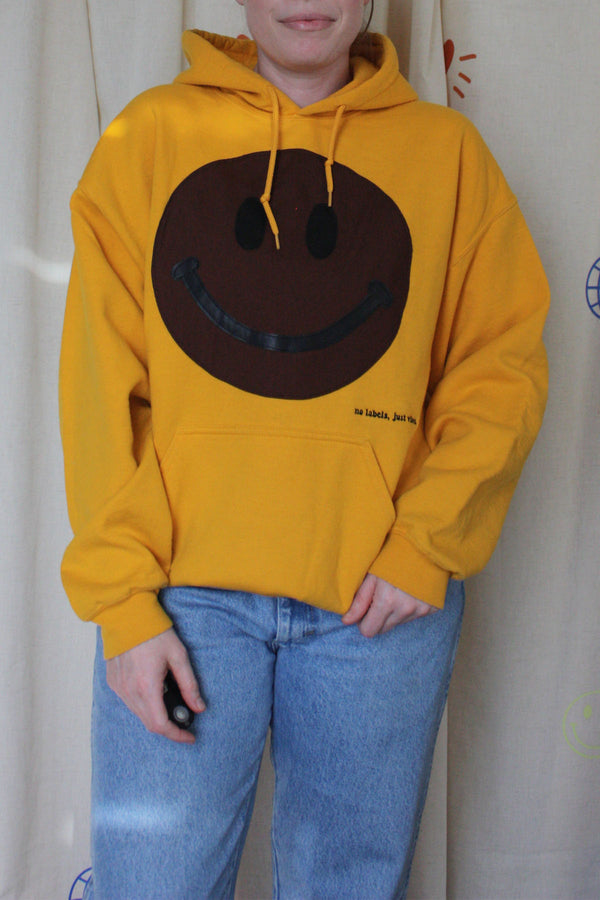 yellow upcycled sweater with brown smiley face, repurposed in canada