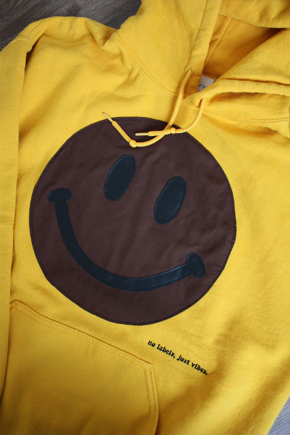 yellow upcycled sweater with brown smiley face, repurposed in canada